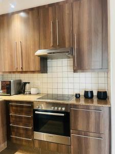 uma cozinha com armários de madeira e um forno com placa de fogão em Marble nights em Joanesburgo