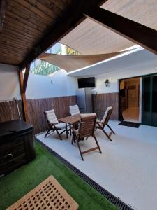 patio con mesa, sillas y TV en Casa Oreo, en Playa Blanca
