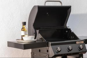 a bottle of wine sitting on a barbecue grill at Casa del Aire in Aldea de Trujillo