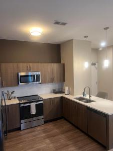 an empty kitchen with a stove and a sink at New Modern 1 BR in Heart of Midtown in Kansas City