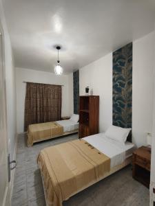 a bedroom with two beds and a dresser at Dar Barka in Kebili