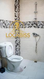 a bathroom with a toilet and a sign on the wall at LOCABISS in Rufisque