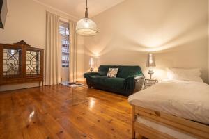 uma sala de estar com uma cama e um sofá em Alojamento Duque D`Avila em Aveiro