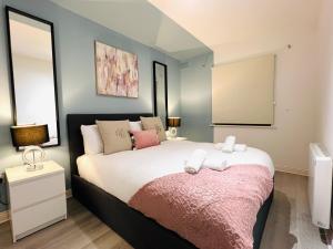 ein Schlafzimmer mit einem großen Bett mit einer rosa Decke in der Unterkunft Luxury Flat at Temple Bar Dublin in Dublin