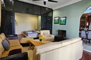 uma sala de estar com um sofá e uma mesa em Kenyalang Piasau Homestay em Miri