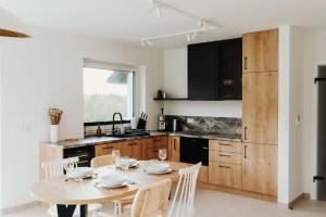 a kitchen with a table and chairs and a kitchen with black cabinets at Janosikowa Polana Szczawnica, Jaworki - domki in Szczawnica