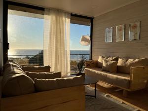 sala de estar con sofá y ventana grande en Cabañas Pacífico Matanzas Completa en Matanzas