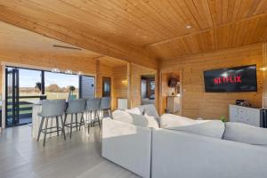 a living room with a white couch and a tv at Choller Farm Lodge - Private Hot Tub in Slindon