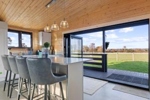 a kitchen and dining room with a table and chairs at Choller Farm Lodge - Private Hot Tub in Slindon