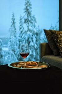 um prato de comida e um copo de vinho numa mesa em Villa Auroras Kettu em Syöte