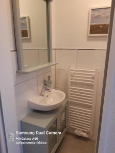 uma casa de banho com um lavatório e um espelho em Haus Sandglöckchen em Greetsiel