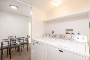 Private/Quiet 2-Bed Apartment في دايتون: مطبخ مع أجهزة بيضاء وطاولة مع كراسي