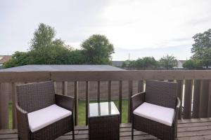 zwei Stühle auf einer Terrasse mit einem Zaun in der Unterkunft Private/Quiet 2-Bed Apartment in Dayton