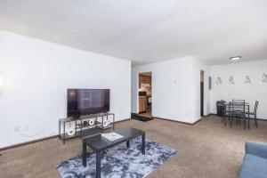 Private/Quiet 2-Bed Apartment في دايتون: غرفة معيشة مع تلفزيون وطاولة