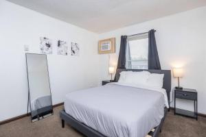 ein weißes Schlafzimmer mit einem Bett und einem Fenster in der Unterkunft Private/Quiet 2-Bed Apartment in Dayton