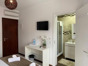 un bagno bianco con lavandino e specchio di The Rock Guest House a Ponta Delgada