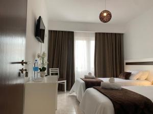 una camera d'albergo con due letti e una scrivania di The Rock Guest House a Ponta Delgada