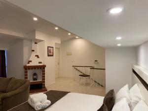 The Rock Guest House في بونتا ديلغادا: غرفة معيشة مع أريكة ومدفأة