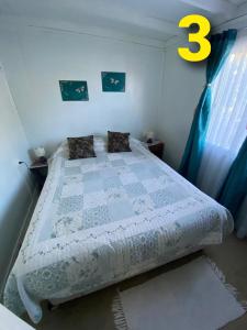 a bedroom with a bed with a blue and white quilt at Departamentos Puerto Montt in Puerto Montt