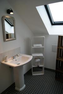 ein Bad mit einem Waschbecken und einem Spiegel in der Unterkunft La Grange De Salomé in Salomé