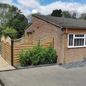 a wooden fence in front of a house at The Woodpeckers - Alresford Essex in Alresford