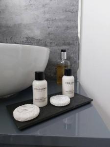 two bottles of soap on a black tray next to a sink at The Woodpeckers - Alresford Essex in Alresford