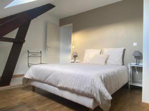a bedroom with a large bed with white sheets and pillows at HORTENSE in Guilliers
