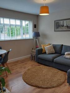 a living room with a blue couch and a table at The Woodpeckers - Alresford Essex in Alresford