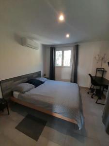 a bedroom with a bed and a desk and a window at Appartement spacieux &très calme. Spacious & very quiet apartment. in Carros