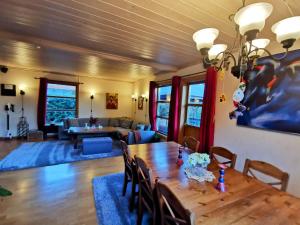 a dining room with a wooden table and a living room at Mikael's Bed & Spa in Sandefjord