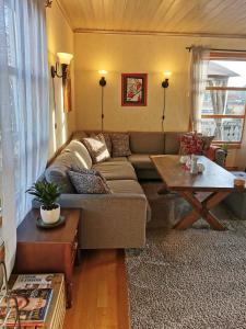 un soggiorno con divano e tavolo di Mikael's Bed & Spa a Sandefjord