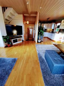 a living room with a large television and a wooden floor at Mikael's Bed & Spa in Sandefjord