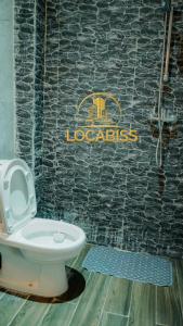 baño con aseo y cartel en la pared en LOCABISS Appartement VIP, en Rufisque