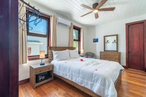 a bedroom with a bed and a ceiling fan at Backroads Sunset + The PoolClub at Mahogany Bay in San Pedro