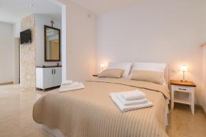 een slaapkamer met een groot bed met handdoeken erop bij Superior Apartment CASA SPALATO in Split