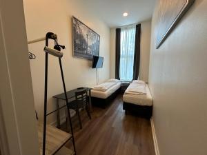 a room with two beds and a desk with a lamp at Hotel Hortus in Amsterdam