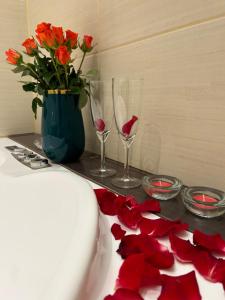 a table with a vase of flowers and wine glasses at Apartamenty Długa 27 in Krakow