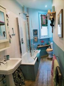 a bathroom with a tub and a sink and a toilet at Highgate apartment with balcony in London