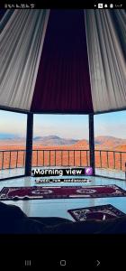 a view of the desert from a room with a viewing window at Wadi Rum Candles Camp in Wadi Rum