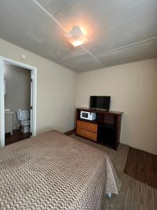 a bedroom with a bed and a television in it at Extended Stay of Carrizo Springs in Carrizo Springs