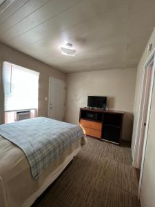 a bedroom with a bed and a flat screen tv at Extended Stay of Carrizo Springs in Carrizo Springs