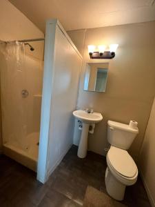 a bathroom with a toilet and a sink and a shower at Extended Stay of Carrizo Springs in Carrizo Springs