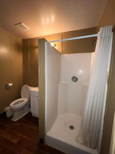 a bathroom with a toilet and a shower with a shower curtain at Extended Stay of Carrizo Springs in Carrizo Springs