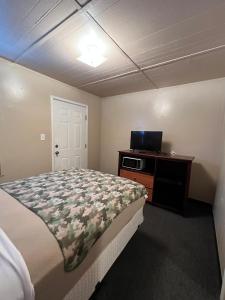 a bedroom with a bed and a desk and a television at Extended Stay of Carrizo Springs in Carrizo Springs