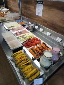 un buffet de denrées alimentaires avec des bananes et d'autres denrées alimentaires dans l'établissement Impar Suites Barao de Cocais, à Barão de Cocais