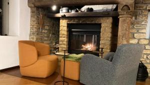 a living room with two chairs and a fireplace at Ancienne Maison Vigneronne in Hauterive