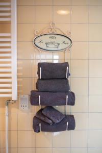 a towel rack with four towels and a clock at Hotel De Koegelwieck Terschelling in Hoorn