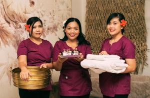 drei Frauen, die einen Teller Kuchen und Handtücher halten. in der Unterkunft Hotel Kotarz Spa&Wellness in Brenna + 212 Fotos