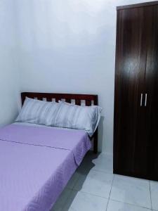 Schlafzimmer mit einem Bett und einem Holzschrank in der Unterkunft Sleep, Eat, Relax with Serenity in Lucena