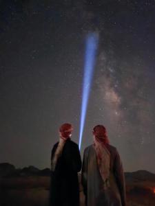 two people looking up at the night sky at Wadi Rum Candles Camp in Wadi Rum